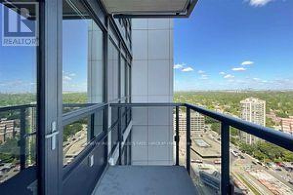 Balcony view from apartment overlooking city buildings and greenery. - 2419 - 5 Sheppard Avenue E, Toronto