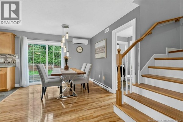 Dining area adjacent to the kitchen with a table, chairs, and sliding glass doors. - 242 Doreen Crescent, Dieppe