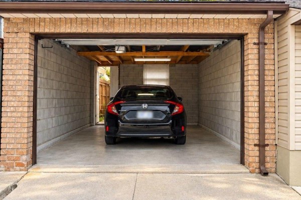 Interior of a one-car garage with a black Honda Civic parked inside. - 242 Silverthorn Avenue, Toronto