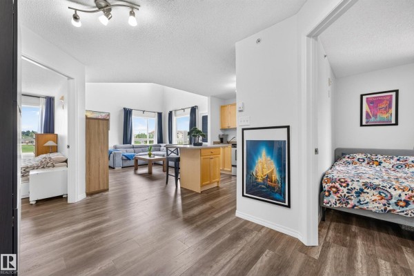 View from hallway into living room, kitchen, and bedrooms on the left and right. - #2420 320 Clareview Station Dr Nw, Edmonton