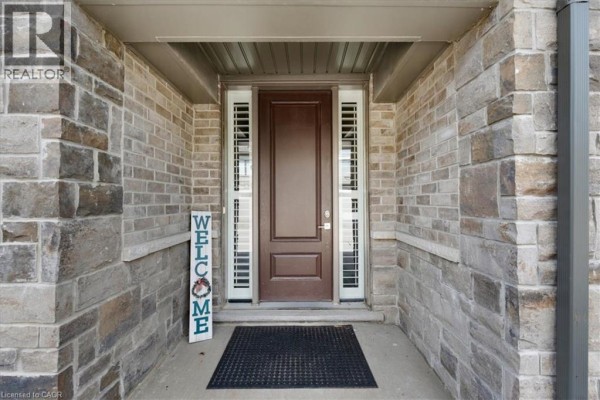 Covered front porch of unit 31 with brown door and welcome sign. - 243 Grey Silo Road Unit# 31, Waterloo