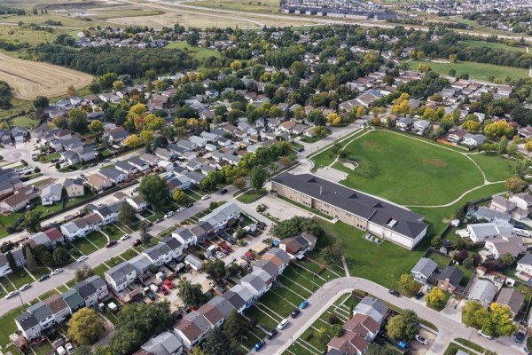 Aerial view of a residential neighborhood with townhouses, a school, and a park. - 243 Houde Drive, Winnipeg