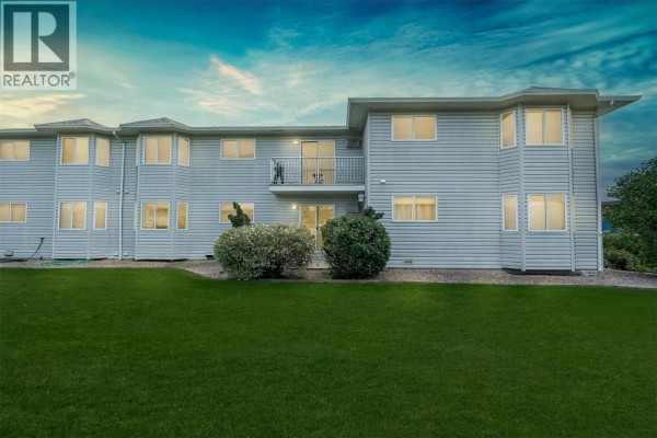Front exterior of the apartment building with a green lawn. - 2435 Pleasant Valley Road Unit# 206, Armstrong