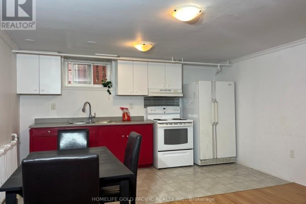 Another view of the basement kitchen area with red cabinets and white appliances. - 244 Maxwell (basement) Street, Toronto