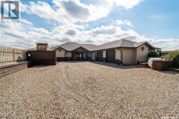 Aerial view of a large house on Crooked Lake with a gravel driveway and manicured lawn. - 244 Moose Road, Crooked Lake