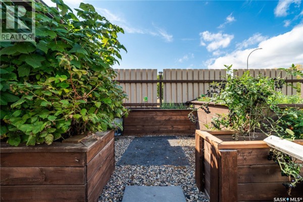 Close-up of raised garden beds with berry bushes and green plants, surrounded by gravel. - 244 Moose Road, Crooked Lake