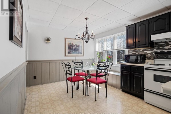 Living room with sofa, armchair, glass coffee table, hardwood floors, and tiered ceiling - 244 North Street Fort Erie