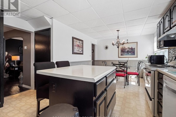Glass dining table with red chairs, dark cabinets, and white appliances - 244 North Street Fort Erie