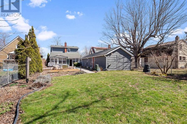 Backyard with patio, fire pit, deck, garage, and large trees - 244 North Street Fort Erie