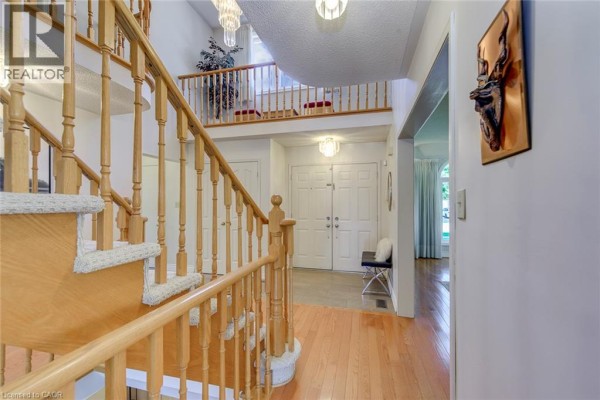Interior entryway with double doors, mirrored wall, and a bench. - 2442 Wynten Way, Oakville