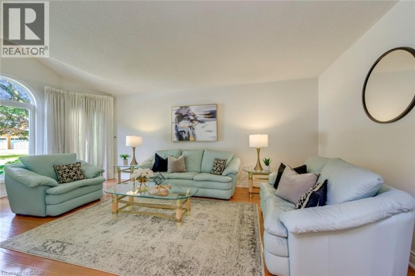 Interior hallway with a carpeted staircase and hardwood floors. - 2442 Wynten Way, Oakville