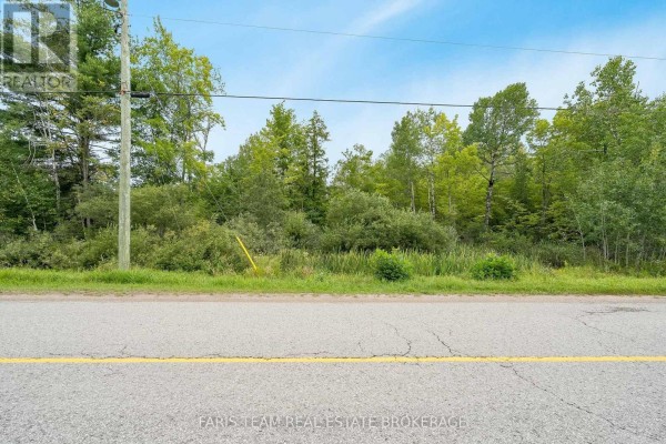 Expansive aerial view of green forest and marshland with scattered bodies of water. - 2444 Fairgrounds Road, Ramara