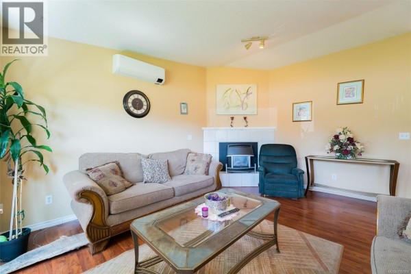 Kitchen with white cabinets, stainless steel appliances, and skylight. - 2446 Divot Dr, Nanaimo