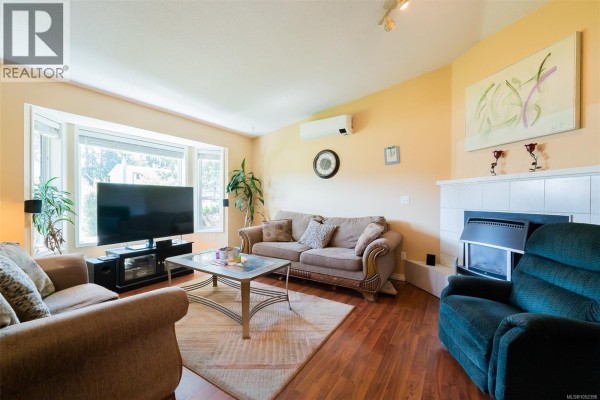 Kitchen with white cabinets, sink, stainless steel refrigerator, and doorway to dining room. - 2446 Divot Dr, Nanaimo
