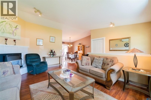 Kitchen with white cabinets, stainless steel appliances, and laundry closet. - 2446 Divot Dr, Nanaimo