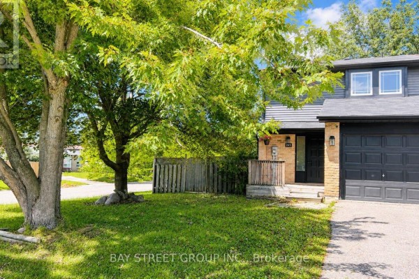 Close-up of the front entrance and garage of a townhouse with brick and siding. - 245 Browning Trail, Barrie