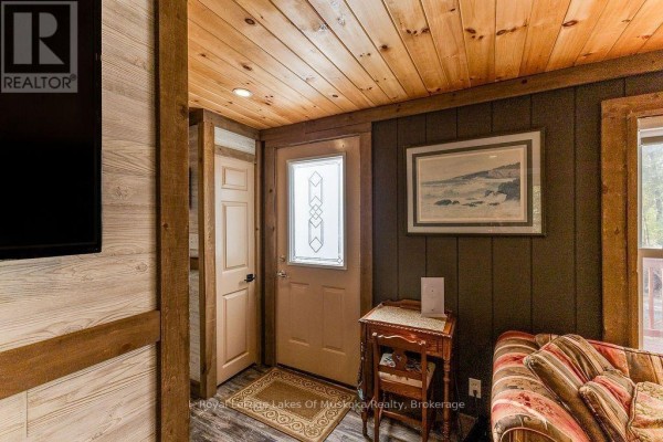 Interior entryway with wood-paneled walls, a beige door, and a framed landscape painting. - 245 Main Street, Kearney