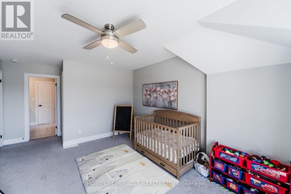 Nursery with crib, play mat, toy organizer, chalkboard, artwork and ceiling fan - 245 Tamarack Boulevard Woodstock