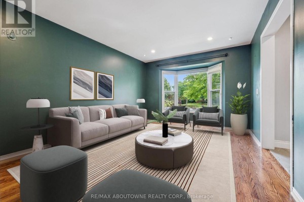 Dining room with dark wood floors, tray ceiling, and green accent wall. - 2456 Sixth Line, Oakville