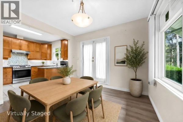 Living room with fireplace, sofa, coffee table, and arched doorway to stairs. - 2459 W 39th Avenue, Vancouver