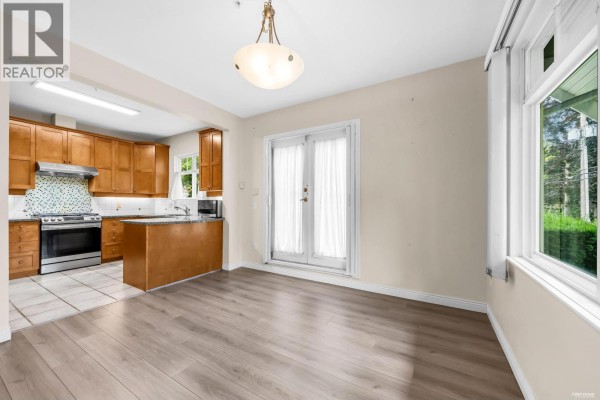 Living room facing fireplace, sofa, coffee table, and double doors. - 2459 W 39th Avenue, Vancouver