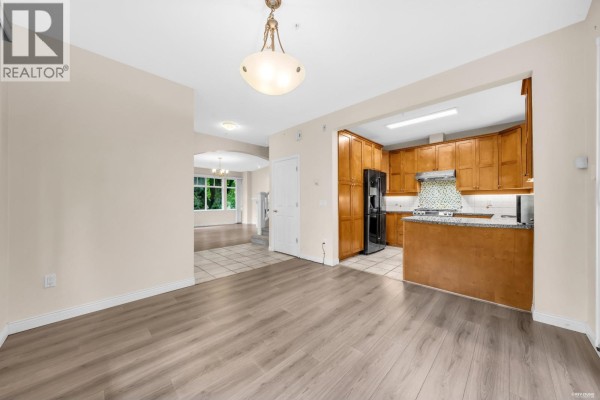Living room with sectional sofa, fireplace, coffee table, and large window. - 2459 W 39th Avenue, Vancouver