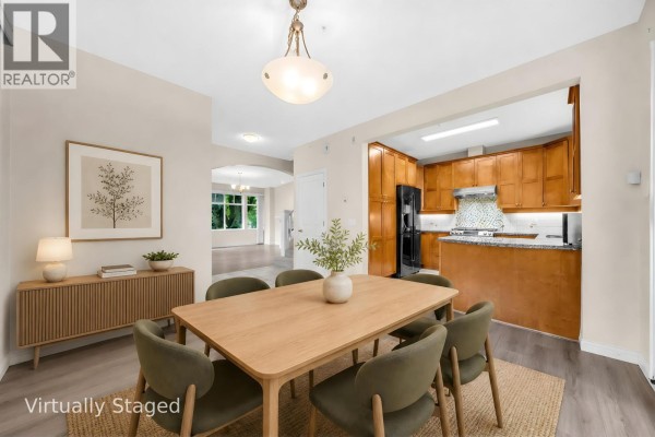 Living room with fireplace, large window, and light wood-look flooring. - 2459 W 39th Avenue, Vancouver