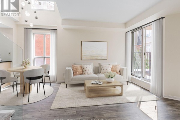 Living area with wood-look flooring, a sliding glass door leading to a balcony, and stairs to upper level. - 246 - 139 Merton Street, Toronto