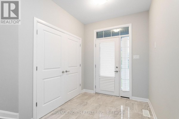 Foyer with light grey walls, marble tile floor, and a double closet. - 246 Aquarium Avenue, Ottawa