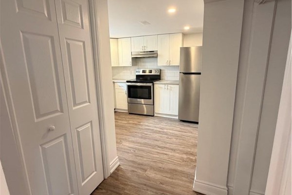 View of the kitchen from a hallway with closed white double doors in the foreground. - 246 East 27th Street, Hamilton