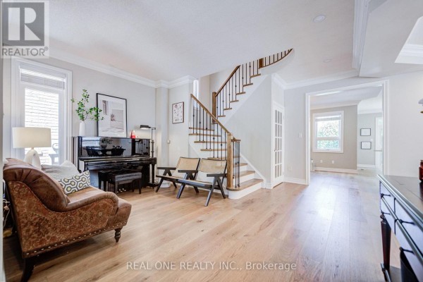 Living area with a piano, sofa, chairs, and view of the staircase and hallway. - 2463 Parkglen Avenue, Oakville