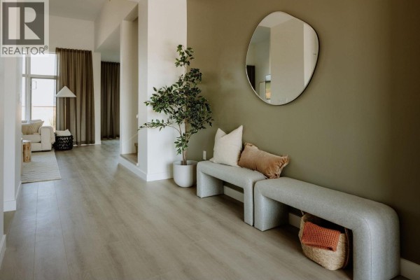 Foyer with light grey L-shaped benches, a large round mirror, and a potted plant. - 2464 Alder Way, Tsawwassen