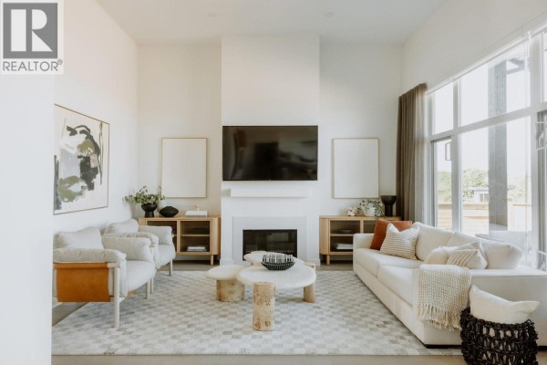 Living room with a white sofa, accent chairs, fireplace, and television. - 2464 Alder Way, Tsawwassen