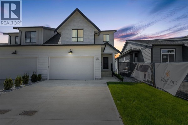 Exterior of the duplex home at dusk with a dramatic sky and streetlights. - 2467 Bradley Drive Unit# 102, Armstrong