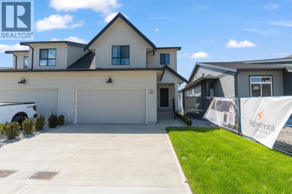 Front exterior of the duplex home with a double garage and concrete driveway. - 2467 Bradley Drive Unit# 102, Armstrong