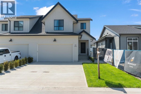 Front of the duplex with a white exterior, large garage door, and landscaping. - 2467 Bradley Drive Unit# 102, Armstrong