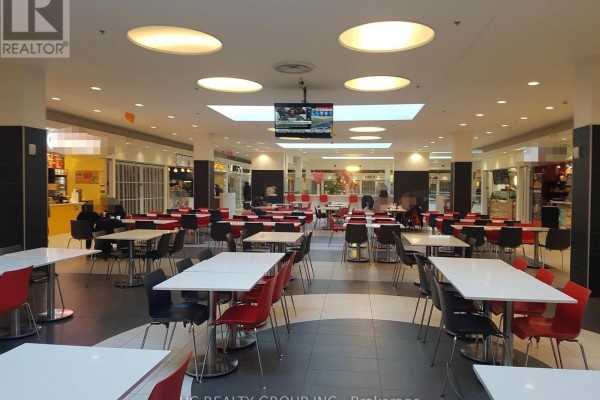 View of a multi-level shopping mall interior with stores, food court, and shoppers on escalators. - 247 - 7181 Yonge Street, Markham