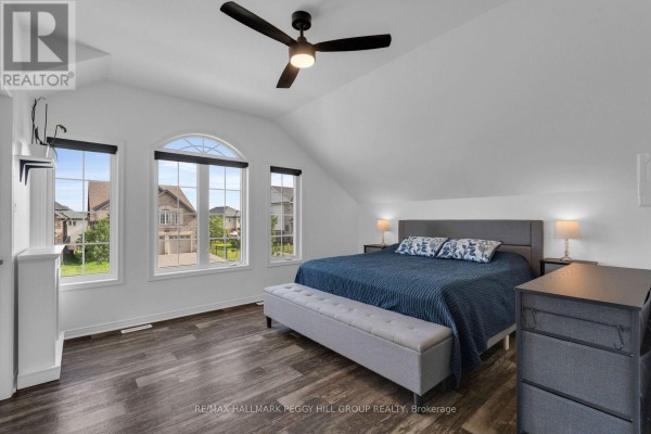Bedroom with a king-size bed, arched window, and sloped ceiling. - 247 Diana Drive, Orillia