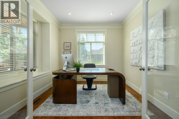 Home office with a large modern desk, chair, computer, and windows with blinds. - 2475 Leggett Drive, Port Moody