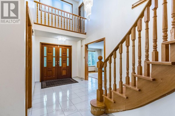 View from the foyer towards double wooden doors and staircase leading to the second floor. - 2477 Cliff Road, Mississauga