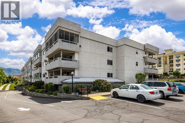 Enclosed sunroom with large windows overlooking the neighborhood and patio furniture. - 2477 Ingram Road Unit# 110, West Kelowna