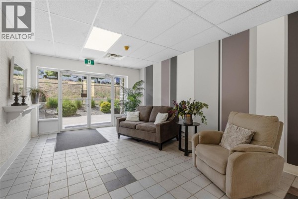 Entrance hallway with a light wood door, closet, and access to a kitchen. - 2477 Ingram Road Unit# 110, West Kelowna