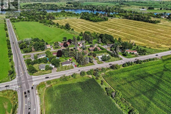 Aerial view of 2477 Merivale Road property surrounded by green fields and rural landscape. - 2477 Merivale Road, Ottawa