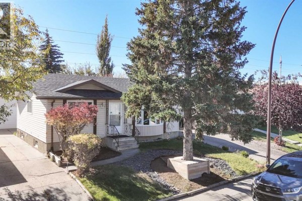 Exterior view of a single-family home with a driveway and surrounding trees. - 248 Bracewood Road Sw, Calgary