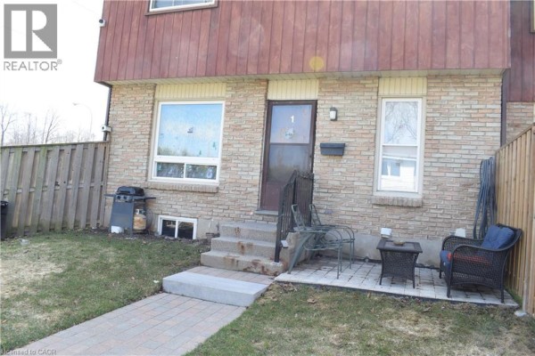 Angle view of the townhouse exterior with a brick walkway leading to the entrance. - 249 Cedarbrae Avenue Unit# 1, Waterloo