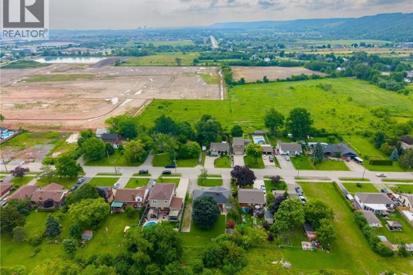 Panoramic aerial view of a suburban neighborhood with surrounding farmland and distant hills. - 249 Mcneilly Road, Stoney Creek