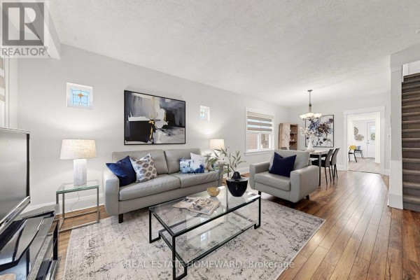 Living room with light grey sofa, grey armchair, glass coffee table, and hardwood floors. - 249 Queensdale Avenue, Toronto