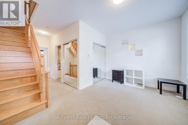 Interior view of a foyer and staircase with mirrored closet and beige carpet. - 249 South Park Road, Markham