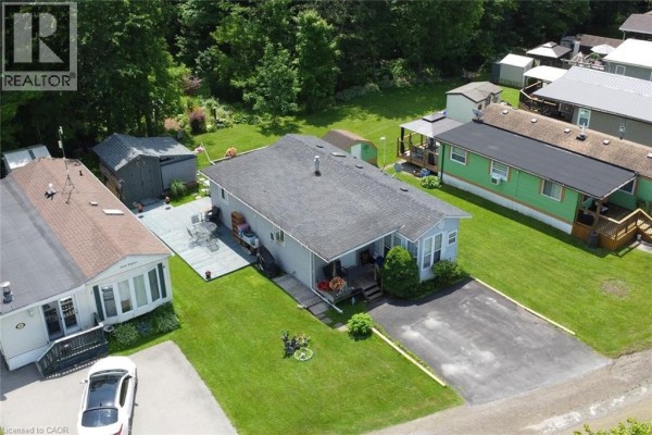 Aerial view of a mobile home park surrounded by trees and green fields, showing rows of homes and roads. - 2490 Governors Road Unit# 41, Ancaster