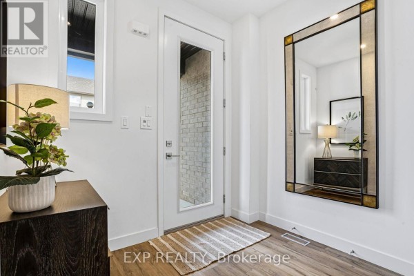Townhouse entryway with a white door, dark wood console, and a large decorative mirror. - 25 - 166 Mount Albion Road, Hamilton